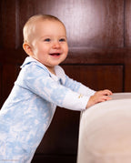Bébé debout, qui porte une combi-pyjama collection Bleu Shayane.