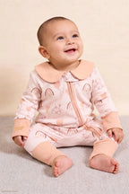 Bébé assis, qui porte une combi-pyjama collection Nuage Moka.