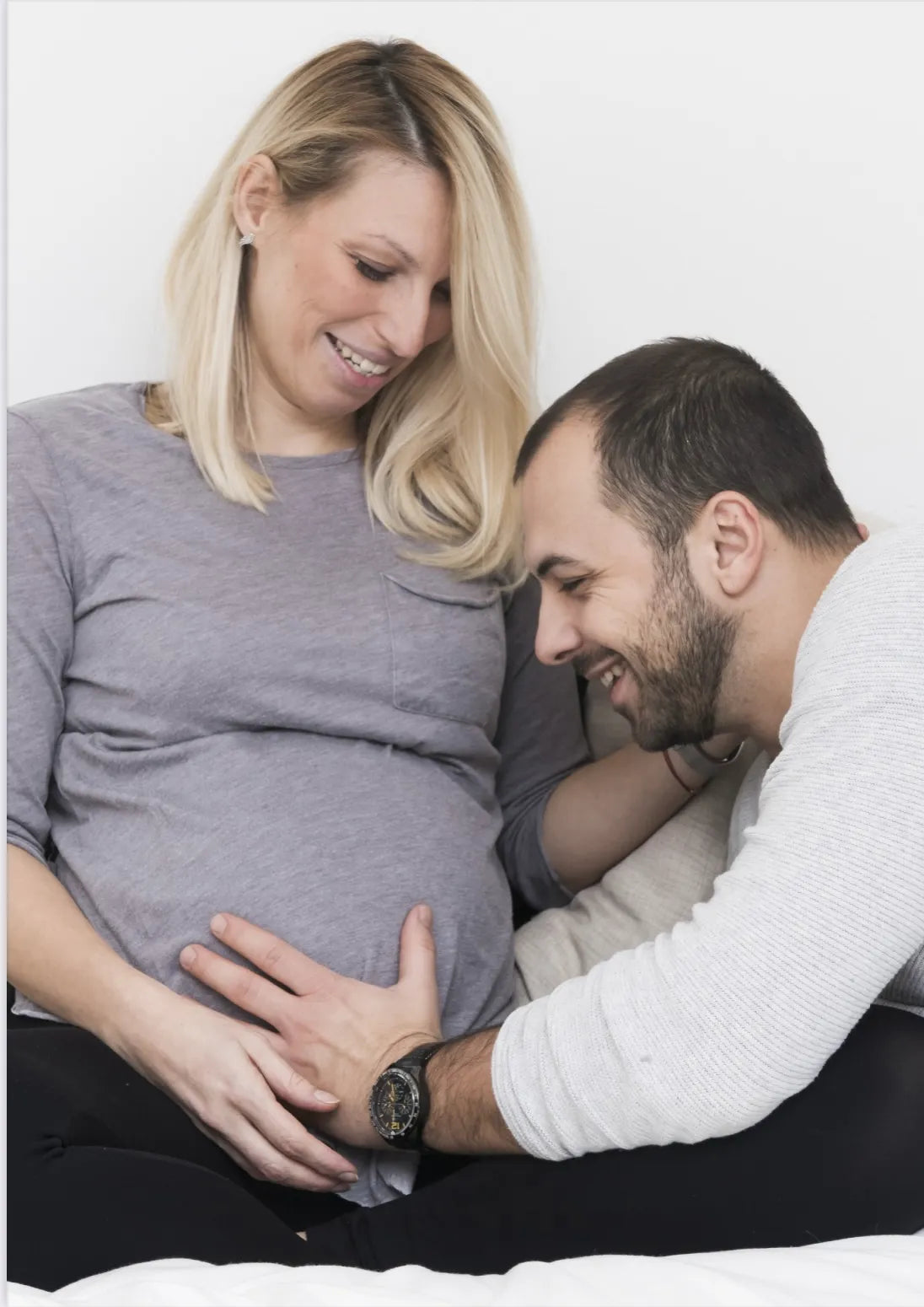 Image d'une femme enceinte avec un homme qui touche son ventre. Dans E-BOOK "Une grossesse, un accouchement". Rédigé par Louana Becker fondatrice de My First Step Academy.