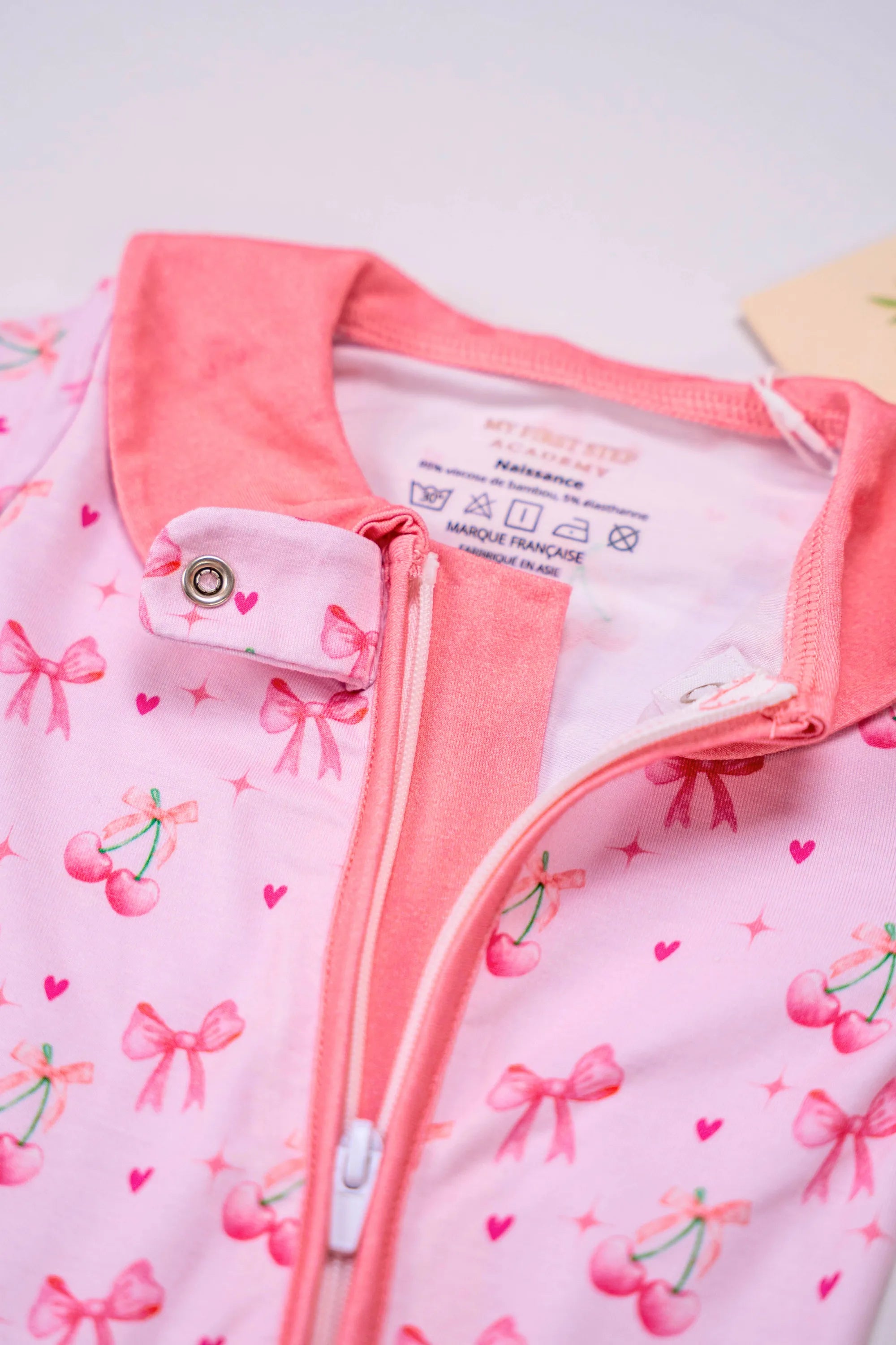 Pyjama Meringue Coquette avec zoom sur la fermeture et étiquette de fabrication. Taille naissance.